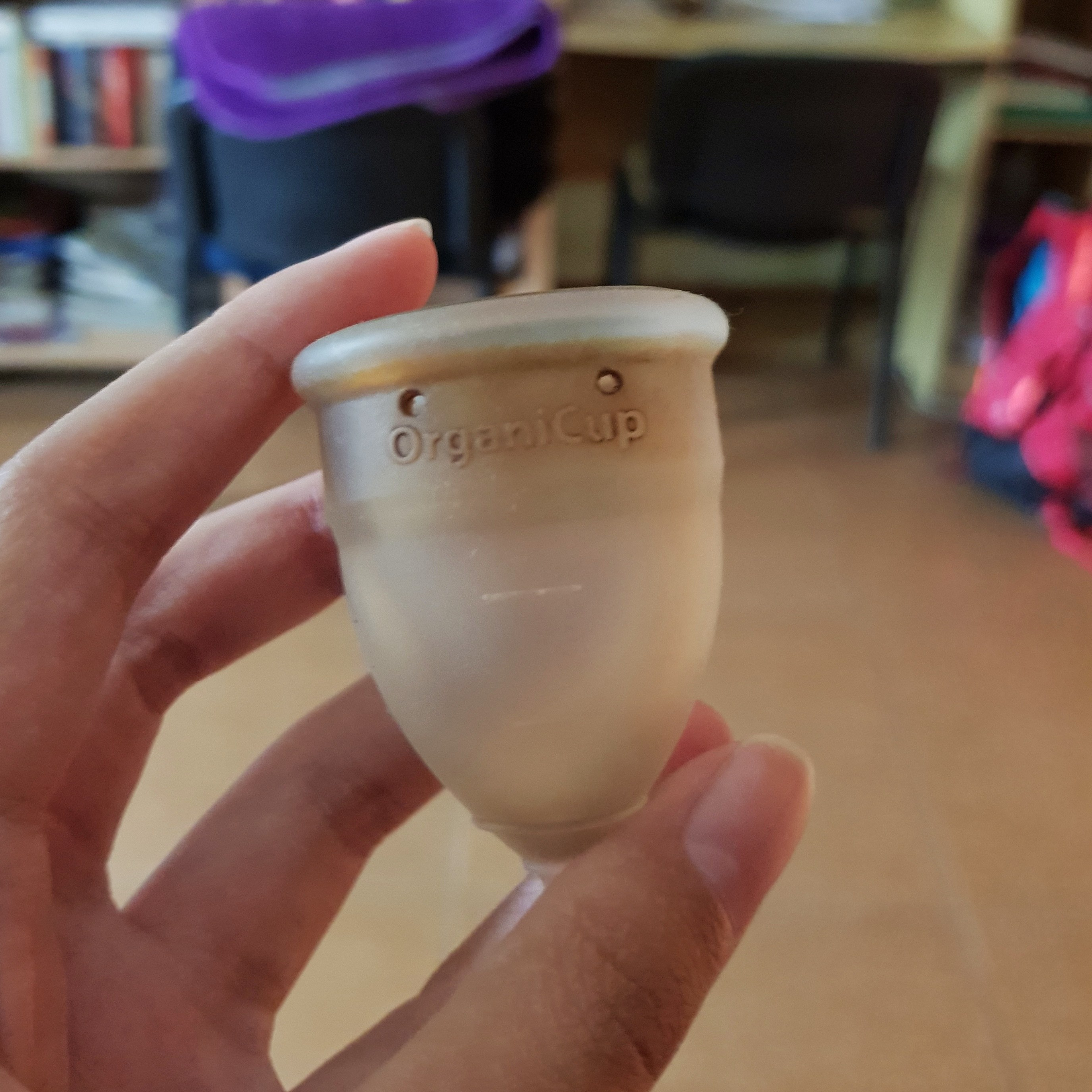 A menstrual cup being held by a hand