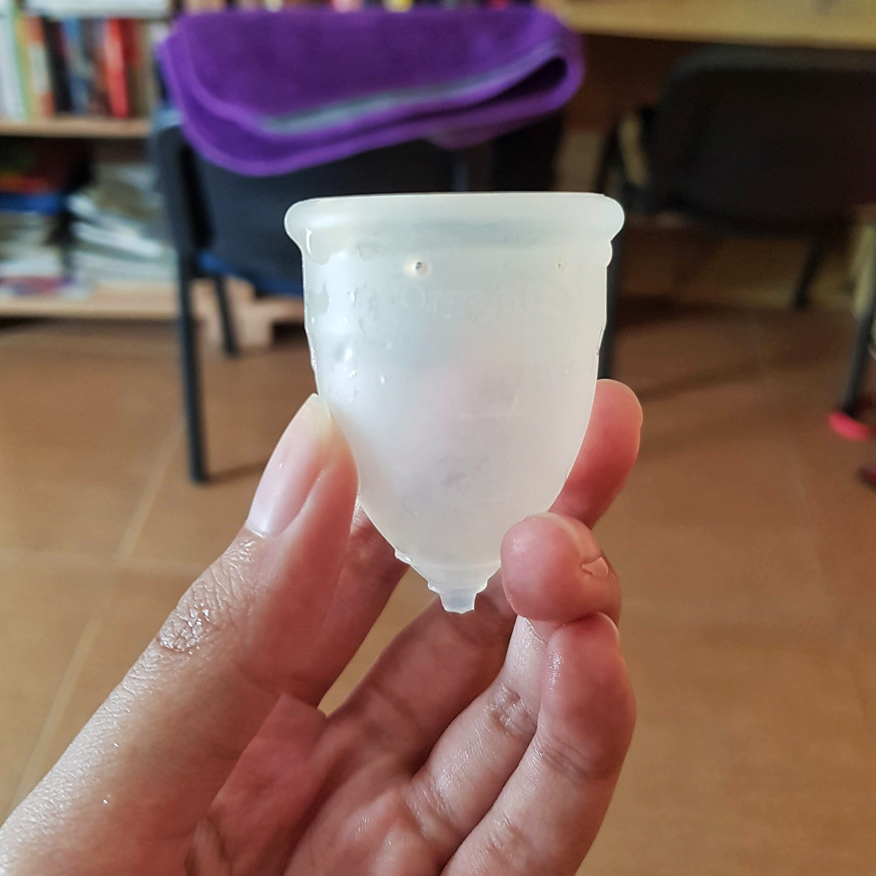 A menstrual cup being held by a hand