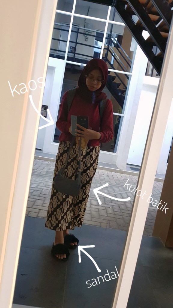 Woman taking self-photograph in front of a mirror showcasing her outfit